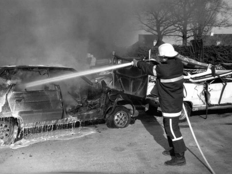 Pascal Merlhès en tenue de pompier testant un lance à incendie